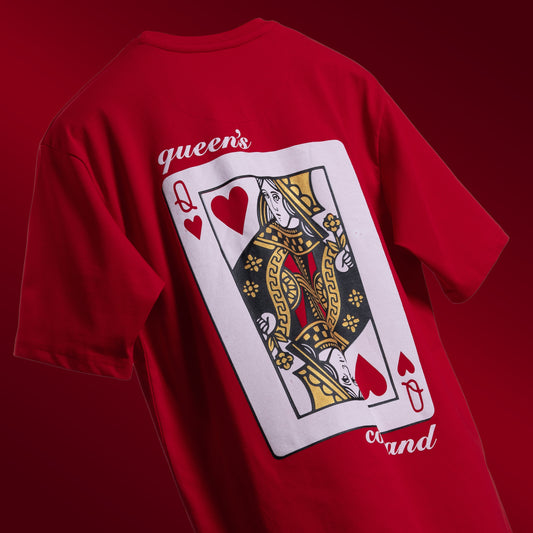 Striking red oversized 'Queen's Command Tee' floating against a matching backdrop, featuring 'Cobalt Green' branding on the front. The back showcases the bold 'Queen's Command' phrase with an intricately illustrated Queen of Hearts card in screen and puff print. Crafted from 220 GSM cotton-rich fabric with bio-washed and gold-finished treatment for a soft, premium feel. The oversized, unisex design offers a relaxed, flattering fit, perfect for expressing confidence and royal style.