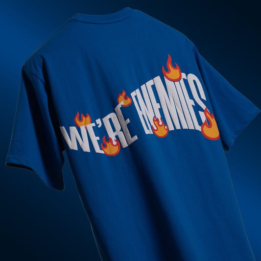 Striking royal blue oversized 'We're Enemies Tee' floating against a matching backdrop, featuring 'Cobalt Green' branding on the front. The back showcases the bold 'We're Enemies' phrase with dynamic fire symbols in screen and puff print. Crafted from 240 GSM cotton-rich fabric with bio-washed and gold-finished treatment for a soft, premium feel. The oversized, unisex fit offers a relaxed and flattering look, perfect for adding attitude and style to any casual outfit.