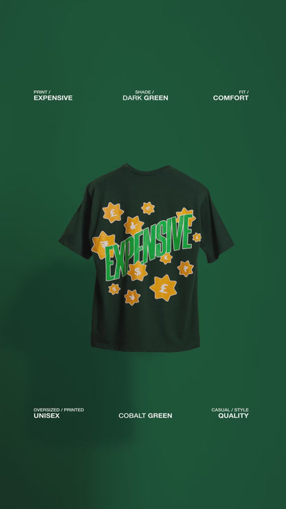 Video showcasing the back of the deep dark green 'Expensive Tee' floating against a matching backdrop. The screen and puff print design of the word 'Expensive' with currency symbols is prominently displayed, emphasizing the luxurious, bold style of the oversized tee.