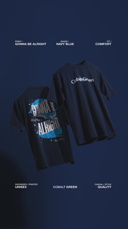 Video showcasing two oversized 'Gonna Be Alright Tees' floating against a matching deep navy blue backdrop, rotating to display both the front and back. The front features 'Cobalt Green' branding, while the back highlights the uplifting 'gonna be alright' phrase and playful blue whale graphics in screen and puff print. The video emphasizes the premium, oversized fit and positive vibe of these unisex tees.